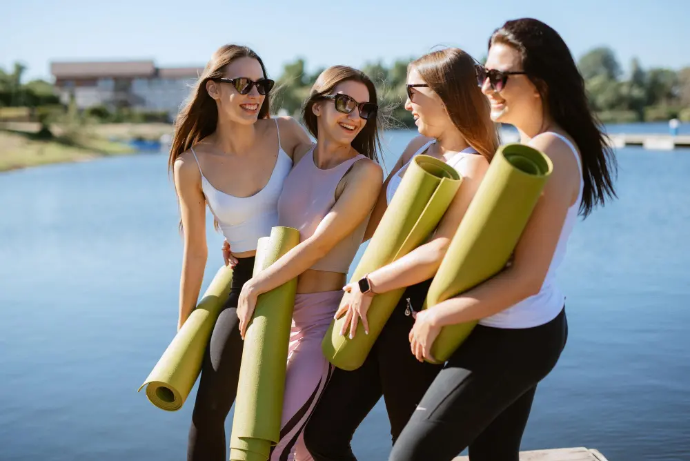 group-young-girls-doing-yoga-outdoors-near-water.jpg