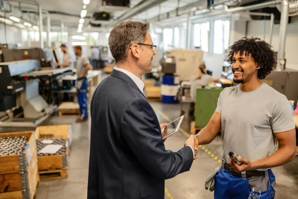 happy-black-manual-worker-shaking-hands-with-company-engineer-factory-plant.