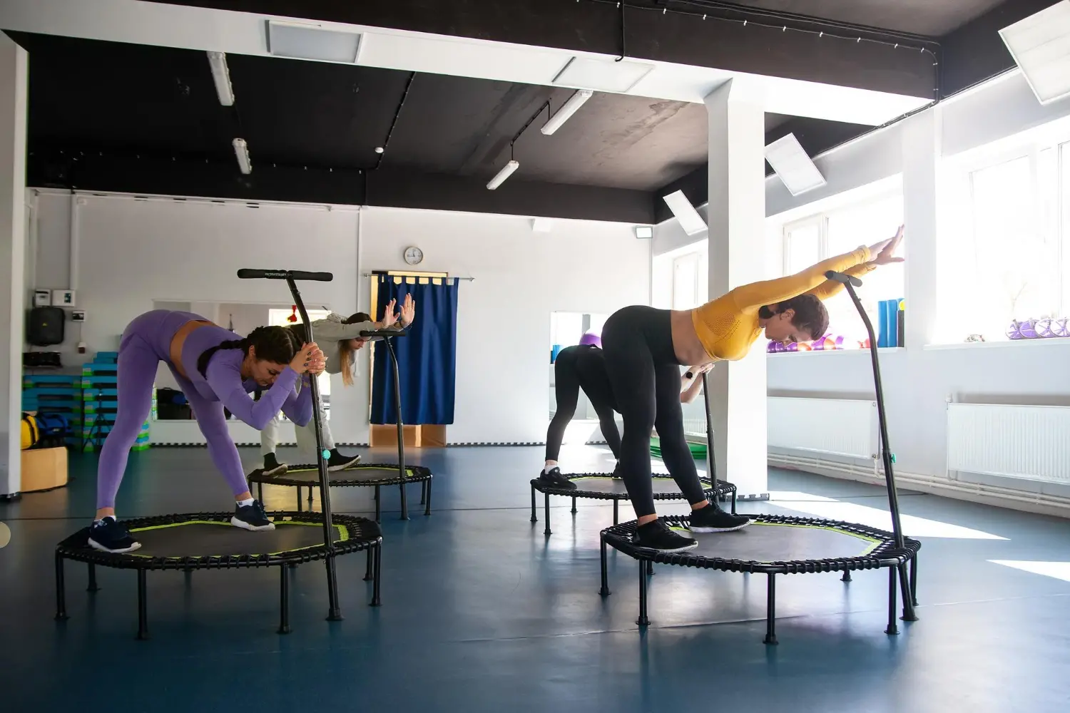 four-young-women-trampoline-young-fitness-girls-trains-fitness-studio.