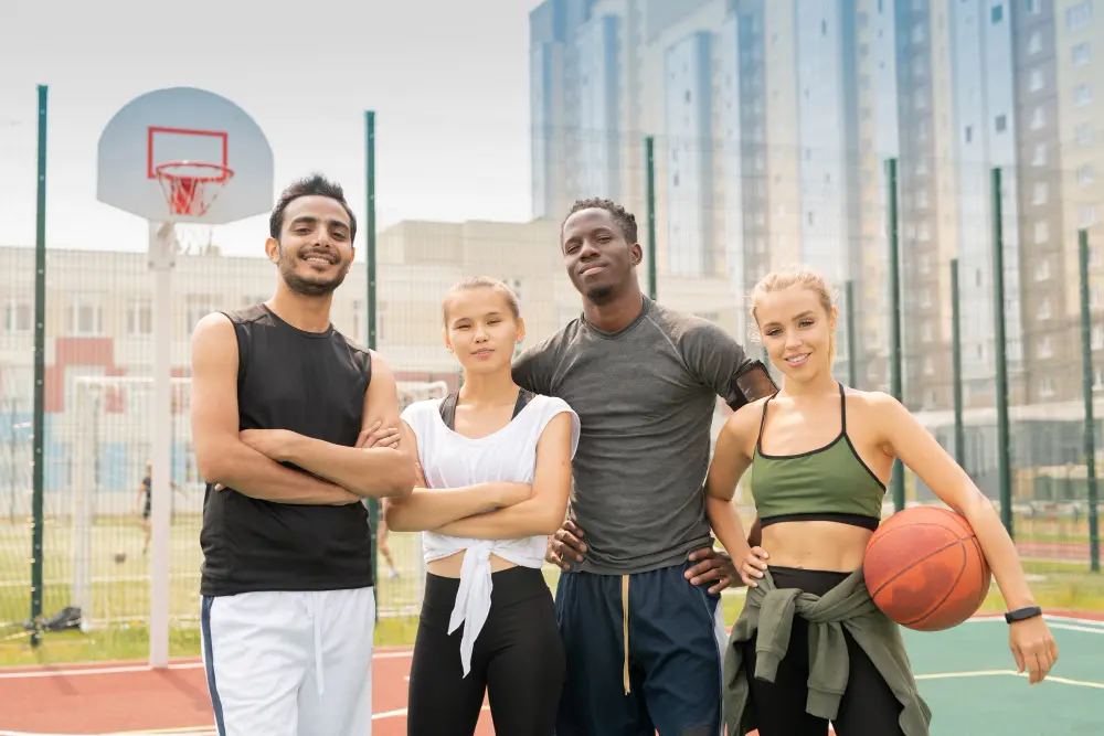 young-cheerful-intercultural-friends-activewear-standing-close-one-another-basketball-playground-stadium