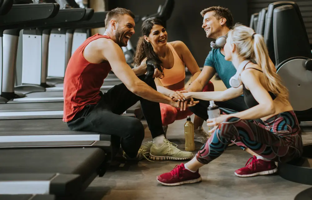 Aprilluck-sportswear-talking-laughing-together-while-sitting-floor-gym-after-workout.